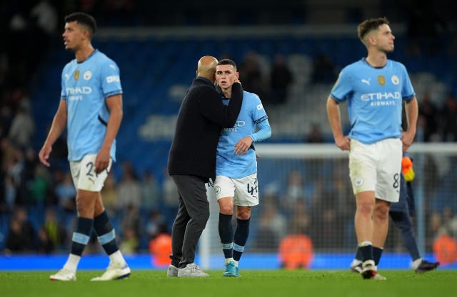 Pep Guardiola, centre left, speaks to Phil Foden as they, Matheus Nunes, left, and James McAtee, right, leave the pitch after Manchester City's win over Watford