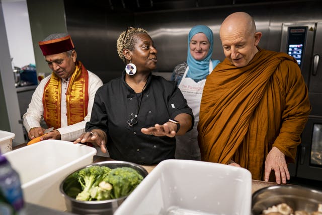 Krishan Kant Attri, Julie Siddiqi and Venerable Ajahn Amaro prepare food as they join other faith leaders in taking part in the Big Help Out, at the Passage in London