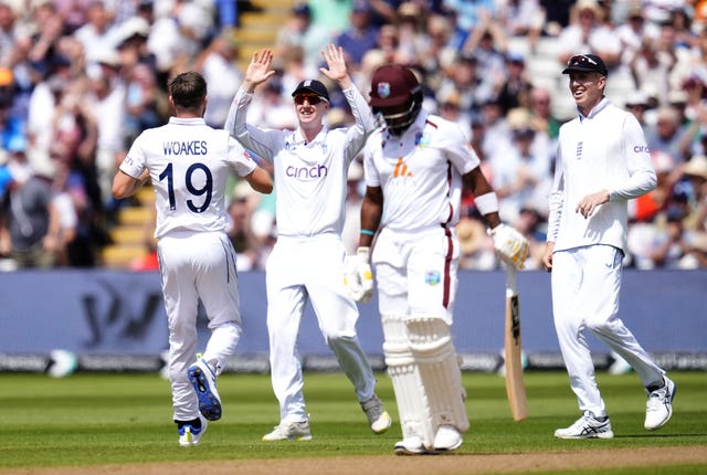 England’s Chris Woakes (left) celebrates with Harry Brook after taking the wicket of West Indies’ Kavem Hodge