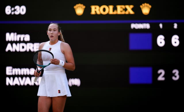 Mirra Andreeva stands in front of the scoreboard