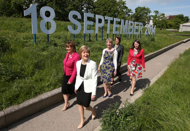 Nicola Sturgeon, Fiona Hyslop, Aileen Campbell, Angela Constance and Shona Robison walking past the sign which announced the independence referendum date as September 18 2014