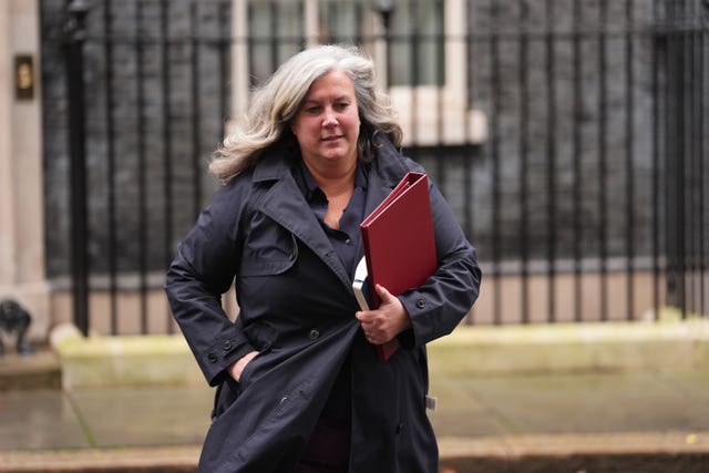 Heidi Alexander walking, with ministerial red folder under her arm