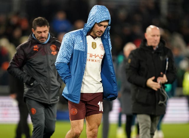 Manchester City’s Jack Grealish, centre, looks dejected as he walks across the pitch at half time after being substituted
