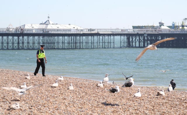A Police community support officer patrols Brighton beach (Andrew Matthews/PA Wire)
