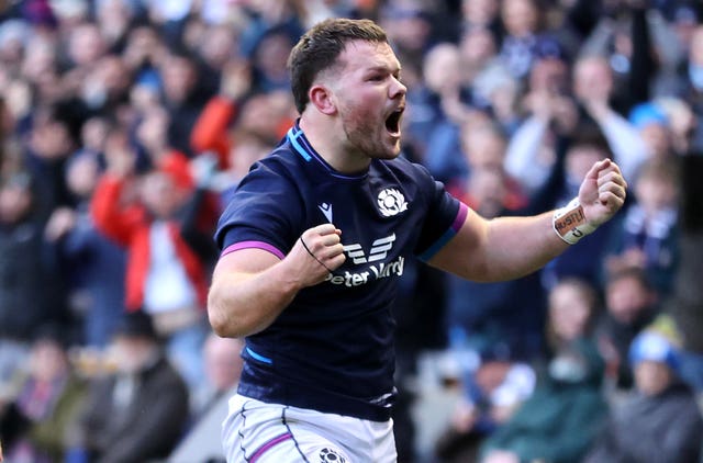 Ewan Ashman clenches his fists to celebrate scoring a try for Scotland