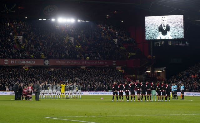 Players from Sheffield United and Manchester United observe a moments silence in tribute to Sir Bobby Charlton