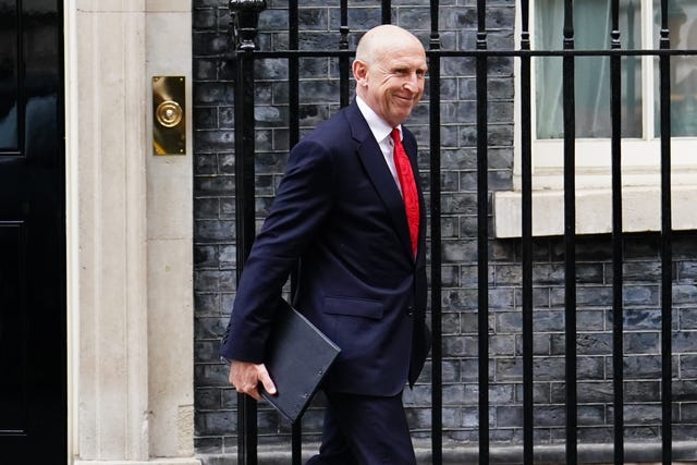 Defence Secretary John Healey, wearing a suit and a red tie, leaves 10 Downing Street.