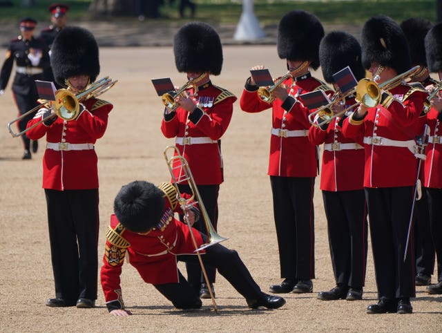 A trombone player in the military band falls to his knees