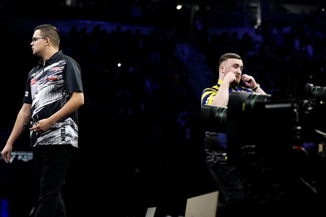 Luke Littler, right, gestures