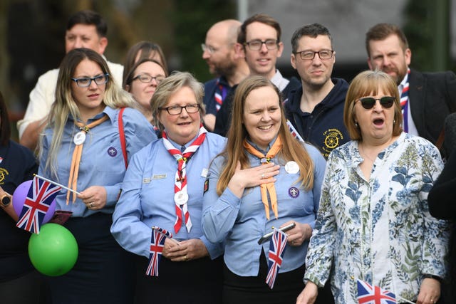 Well-wishers look on during the royal visit