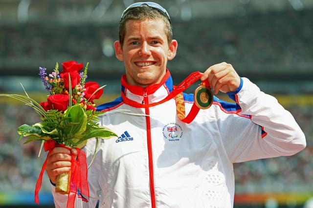 John McFall holding flowers and his bronze medal 