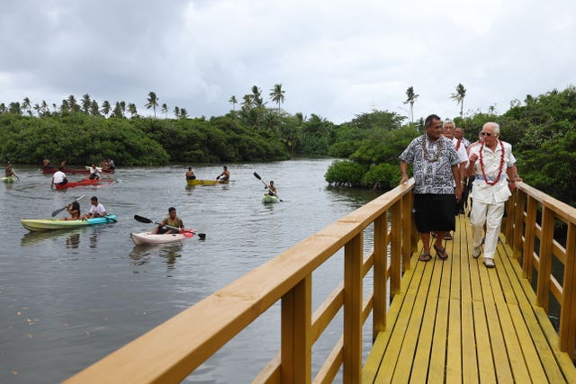 Charles and Minister Toeolesulusulu Cedric Schuster walk across a restored boardwalk during a visit to the Moata’a Village Mangrove Restoration Walk, near Apia in Samoa