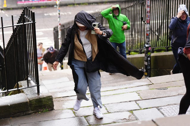 Members of the public battle against the wind as they walk in Edinburgh city centre