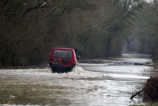 A car drives along a flooded road