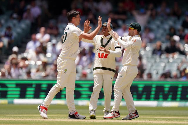 Australia’s Pat Cummins (left) celebrates with Usman Khawaja (centre) and Travis Head (right) 