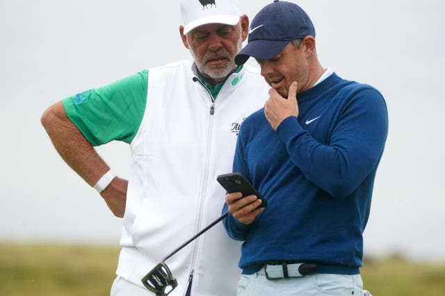 Darren Clarke and Rory McIlroy look at McIlroy's mobile phone