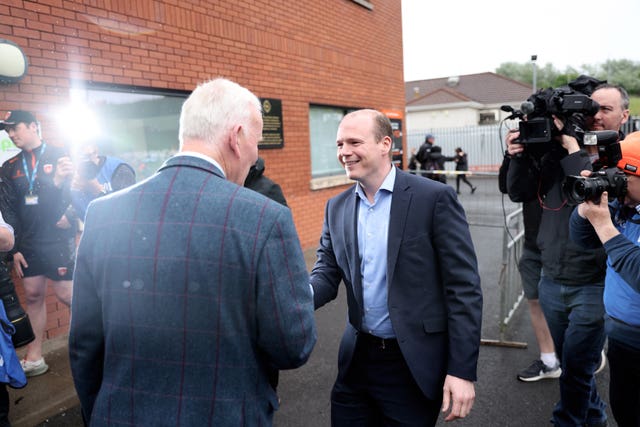 Gordon Lyons (right) is greeted by Michael Geoghegan, president of Ulster GAA, as he arrives at the Athletic Grounds (Peter Morrison/PA)