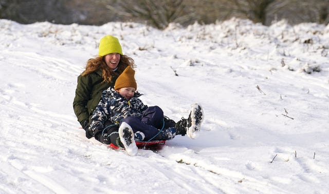 Liz and son Henry sledging on the snow in Tatton Park, Knutsford, Cheshire