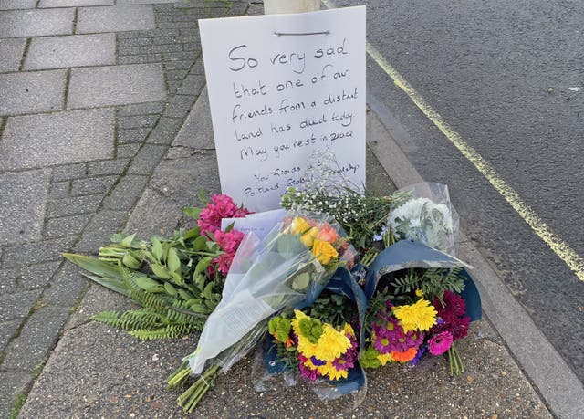 Flowers left at the entrance to the Bibby Stockholm accommodation barge at Portland Port in Dorset following the death of an asylum seeker on board