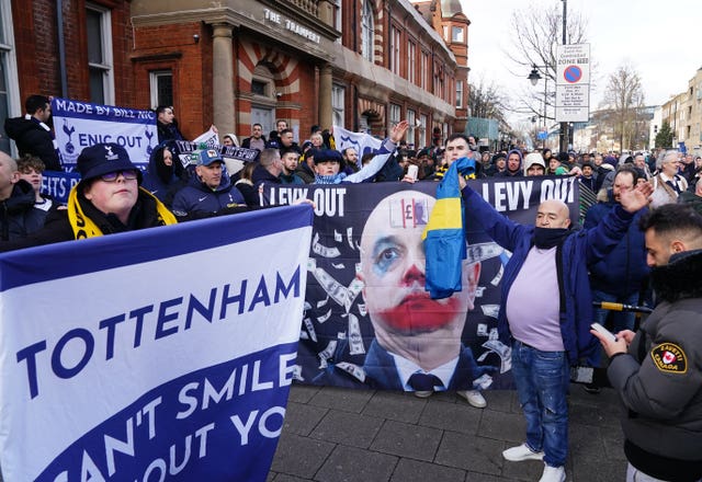 Tottenham fans hold a banner reading 'Tottenham - Can't smile without you', and another reading 'Levy out' with money and clown make-up superimposed on a picture of chairman Daniel Levy