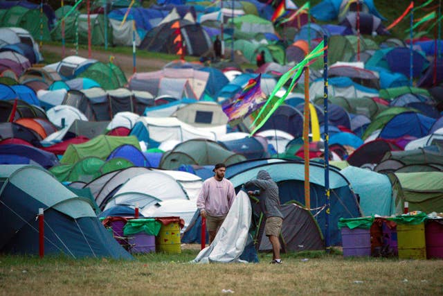 Festival goers pack away a tent