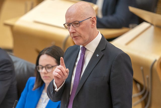 John Swinney pointing while speaking in Parliament