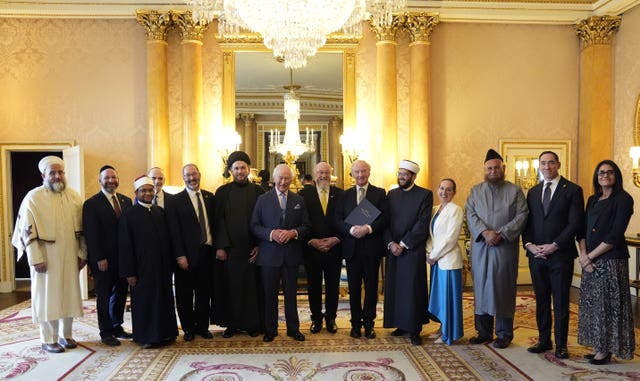 The King poses for a photograph with faith leaders at Buckingham Palace