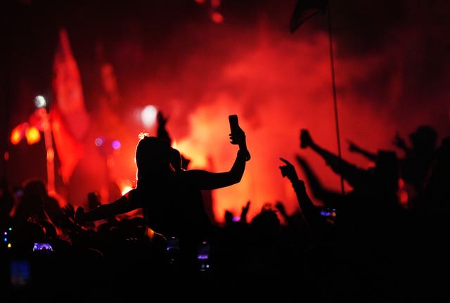 An audience member silhouetted against red smoke