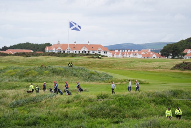 Police officers look on as golfers play at US President Donald Trump’s Turnberry golf course