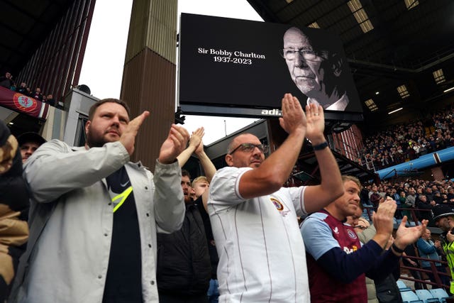 Fans observe a tribute to the late Sir Bobby Charlton ahead of the Premier League match at Villa Park