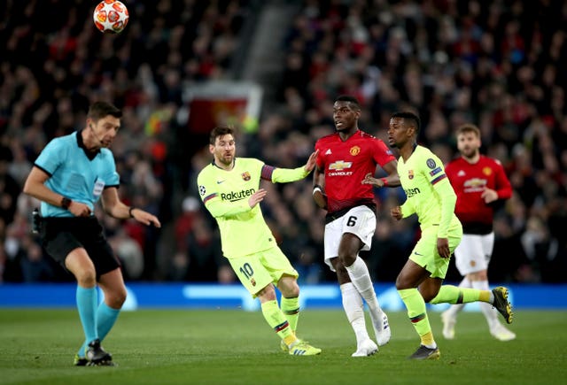 Manchester United's Paul Pogba, centre, battles for possession with Barcelona's Lionel Messi in the Champions League