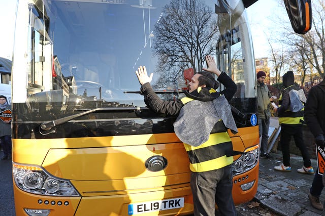 A protester glues himself on to the Liberal Democrats' battle bus