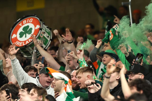 Ireland fans wearing green and orange bang drums