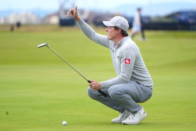 Matt Fitzpatrick squats on a green at Royal Troon