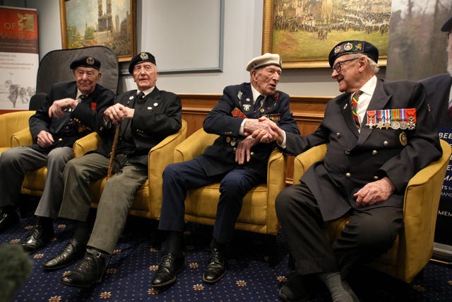 D-Day veterans Alec Penstone (second right), 98, who served with the Royal Navy, shakes hands with Ken Hay (right), 98, ambassador for the British Normandy Memorial who served with the 4th Dorset Regiment 