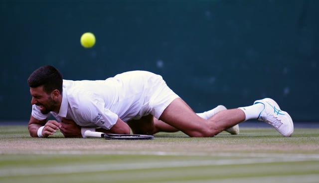 Novak Djokovic looks in pain as he falls to the floor