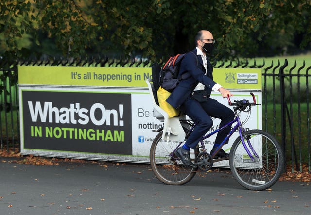 A man wearing a face covering cycling in Nottingham (MIke Egerton/PA)