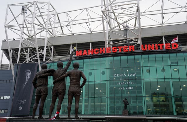 The United Trinity statue, featuring George Best, Denis Law and Sir Bobby Charlton, opposite a tribute to Law at Old Trafford ahead of his funeral procession