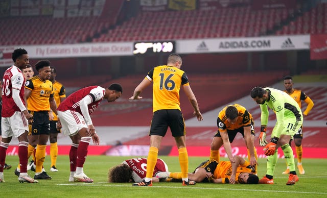 Players show concern after a serious clash of heads between Wolves' Raul Jimenez and David Luiz of Arsenal