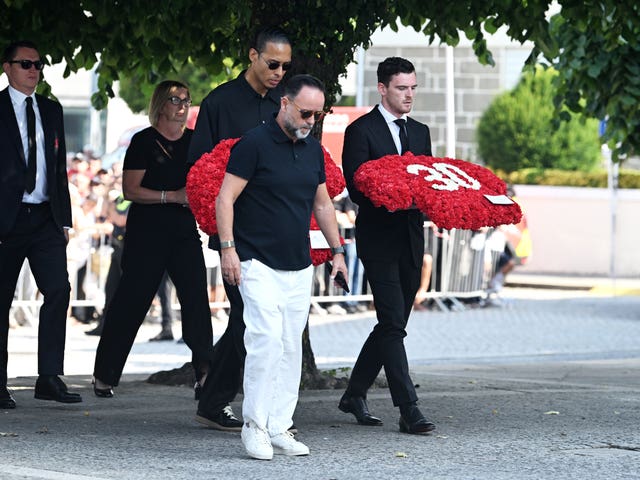 Liverpool players carry a wreath