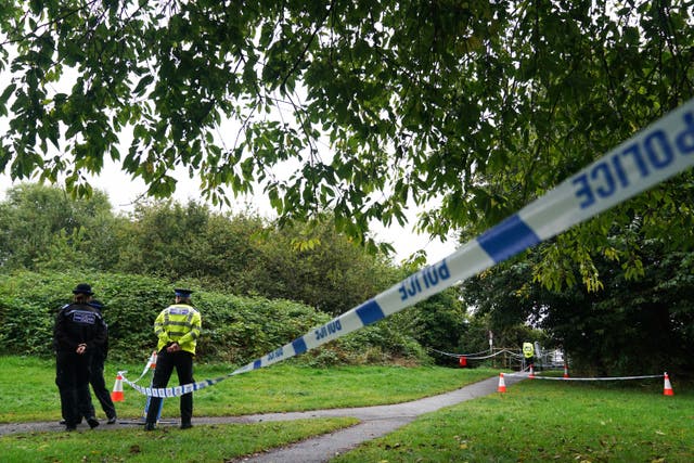 Police officers and police tape at a park