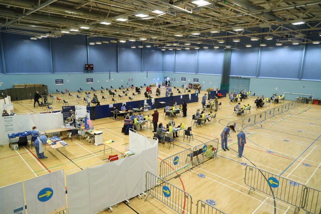 Members of the public receive a dose of the Oxford/AstraZeneca vaccine at a vaccination centre at Cwmbran Stadium in Cwmbran (Geoff Caddick/PA)