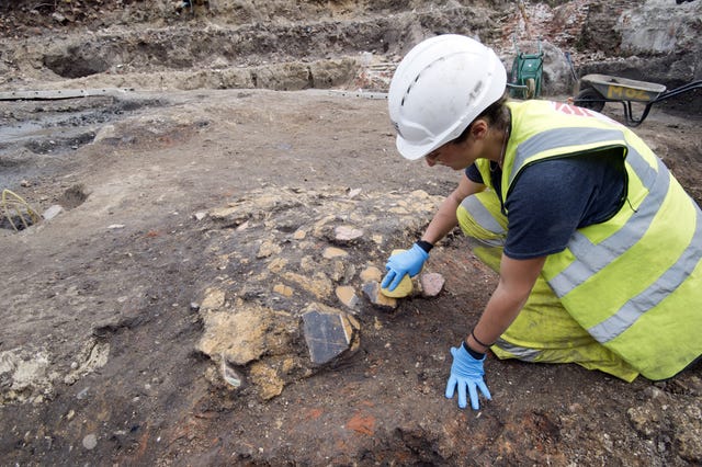 Archaeologists uncovering the wall plaster during excavations at The Liberty Site in Southwark