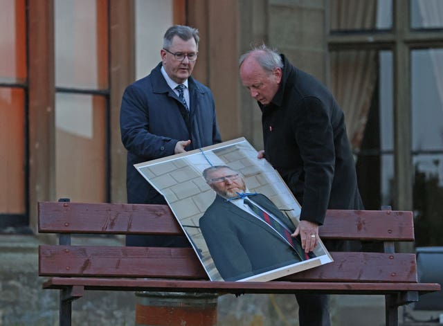 Sir Jeffrey Donaldson and Jim Allister removing the poster 