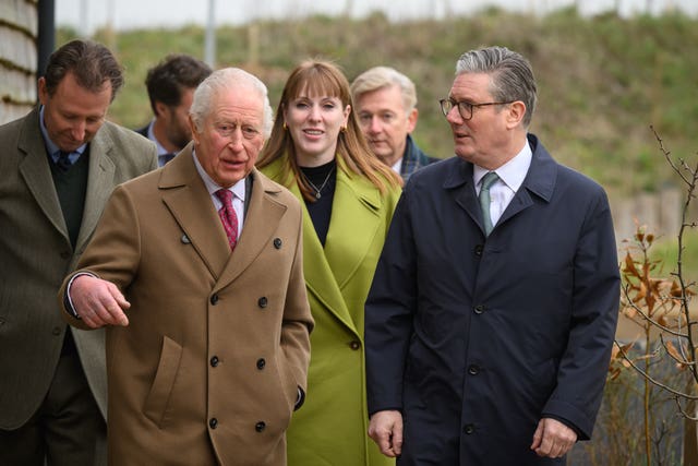 The King walking alongside Sir Keir Starmer, with Angela Rayner behind them