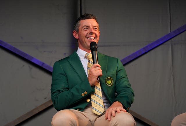 Rory McIlroy, wearing a Masters green jacket, speaking into a microphone