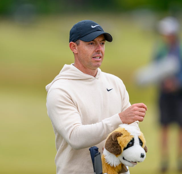 Rory McIlroy leans on his dog headcover