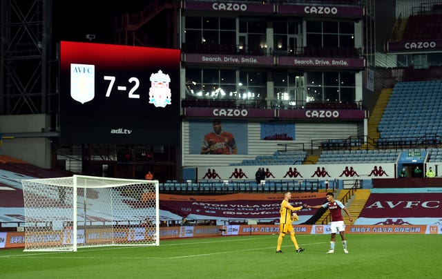 Dejected Liverpool goalkeeper Adrian, left, fist-bumps Ollie Watkins as the scoreboard shows Aston Villa 7 Liverpool 2