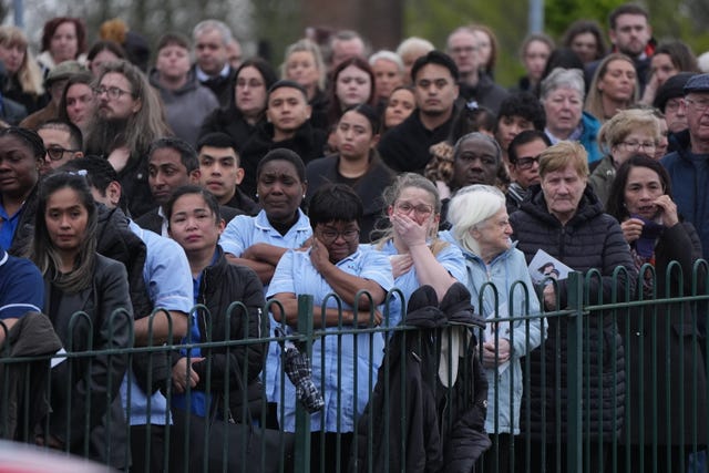 People in healthcare uniform among mourners