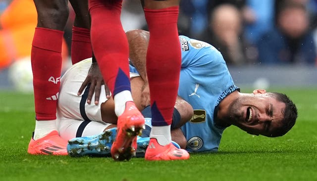 Manchester Cuty midfielder Rodri lies injured clutching his leg in the Premier League game against Arsenal